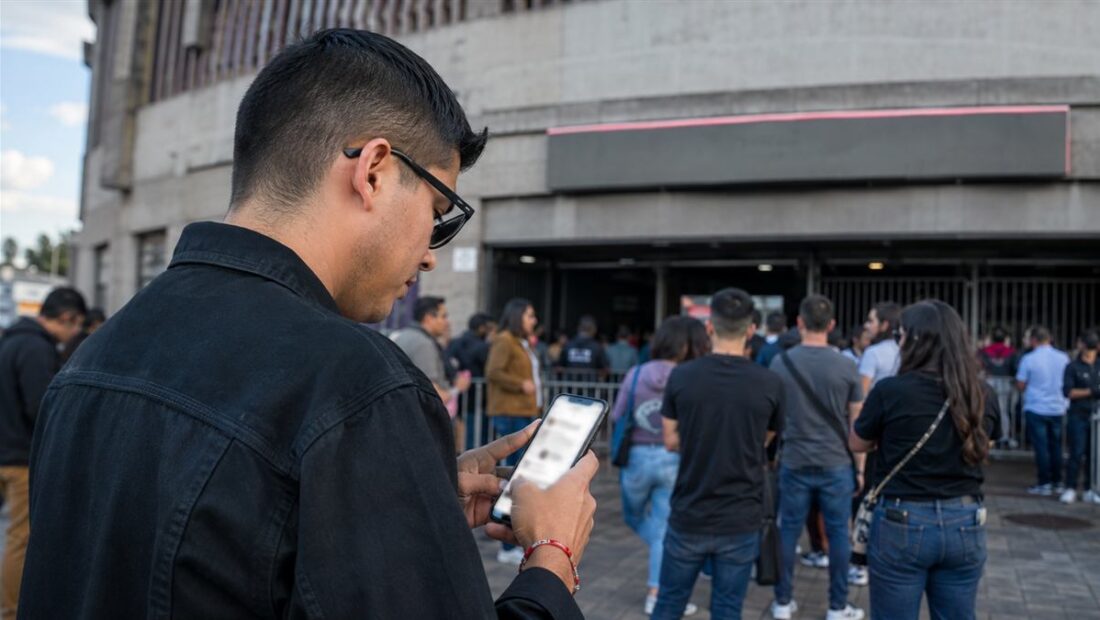 Persona verifica un boleto digital y la información oficial de un espectáculo en su teléfono