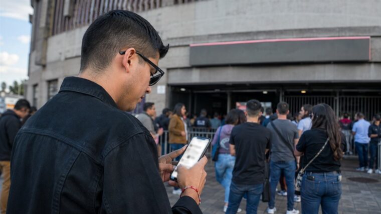 Persona verifica un boleto digital y la información oficial de un espectáculo en su teléfono